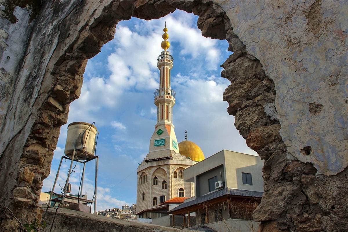 A mosque seen through a stone arch